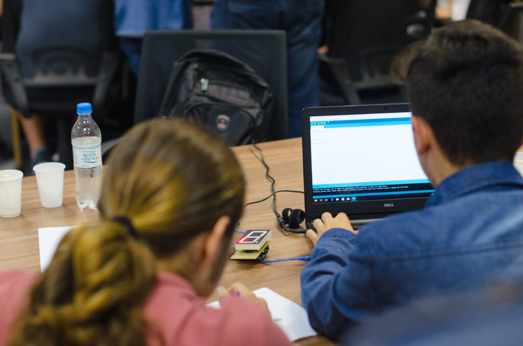 Estudantes resolvendo desafio de programação com Arduino.