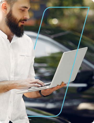 Um homem segura um notebook aberto enquanto olha para a tela do aparelho.