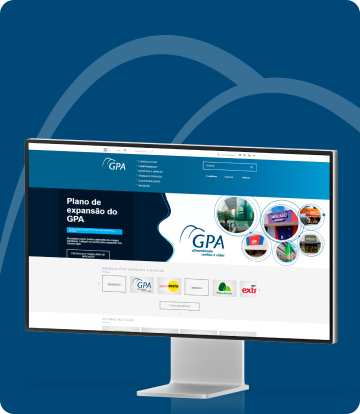 Um monitor exibe o site do GPA sobre um fundo azul-marinho ilustrado pelo ícone do logotipo do GPA.