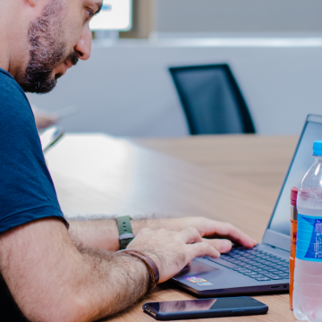 Um homem trabalha em um notebook.