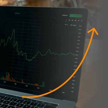 Laptop screen displaying a graph with an orange arrow indicating growth.