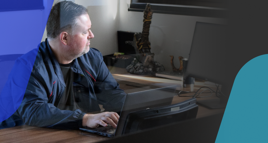 A imagem mostra um homem branco sentado em frente a um notebook. 