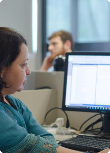 Representando o serviço de sustentação, a foto mostra uma mulher trabalhando em frente a um computador.