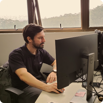 Um homem com camisa da CWI trabalha em frente a um computador.