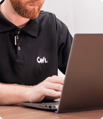 A imagem mostrar um homem branco com as mãos sobre o teclado de um notebook.