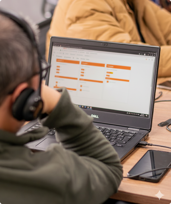 Pessoa trabalhando em laptop Dell exibindo gráficos e dados em laranja na tela.