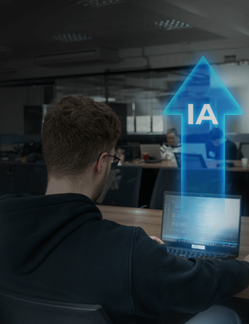 Pessoa trabalhando em notebook em escritório, com seta azul apontando para cima e a sigla IA em destaque.