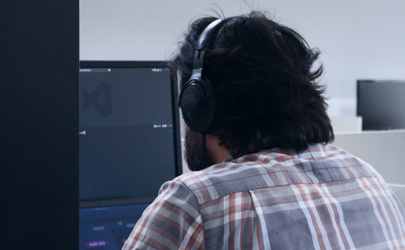 A imagem mostra um smartphone branco inclinado sobre um quebra-cabeça de peças brancas quase completo, onde há um espaço vazio retangular à esquerda revelando um fundo azul sólido. Na tela preta do celular, aparecem quatro peças de quebra-cabeça montadas que exibem um ícone azul de programação. A iluminação é focada no centro, criando bordas escurecidas que dão um tom de mistério e solução de problemas tecnológicos à composição.