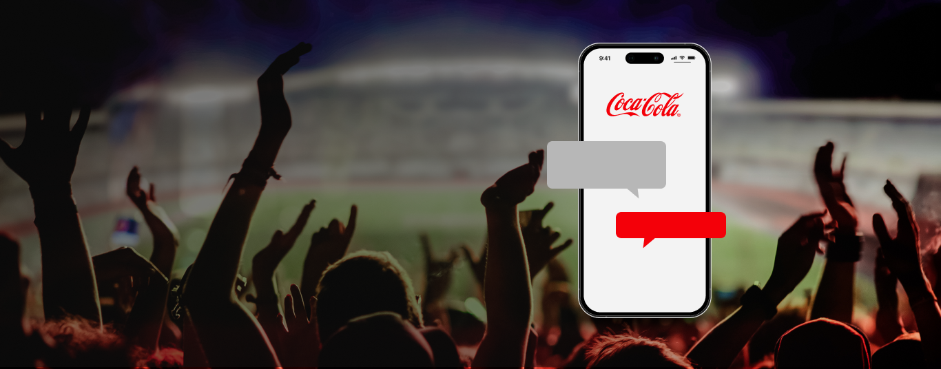Celular com logo da Coca-Cola e balões de chat vazios, sobreposto ao fundo desfocado de uma torcida em um estádio.